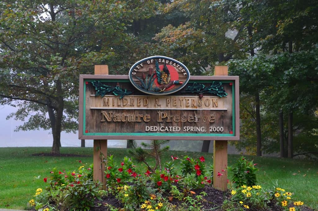 The Mildred Peterson Nature Preserve entrance sign among flowers